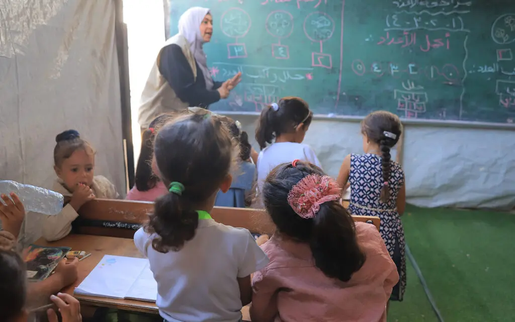 barn och lärare i provisoriskt klassrum