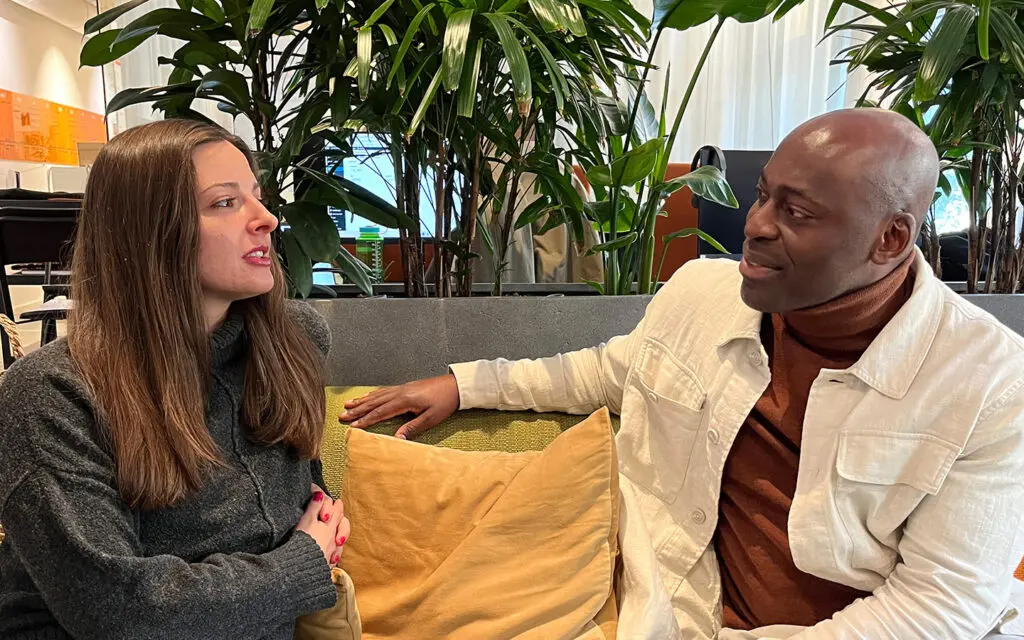 En kvinna och en man samtalar i en soffa