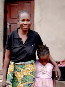 Mamma håller om sin lilla dotter i rosa klänning