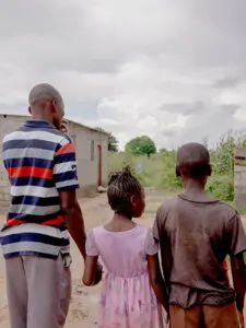 Tre syskon bakifrån håller handen