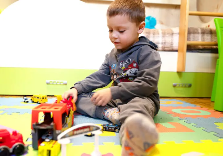 Pojke på golvet leker med lastbil