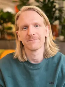 Ung man i ljust hår tittar allvarligt