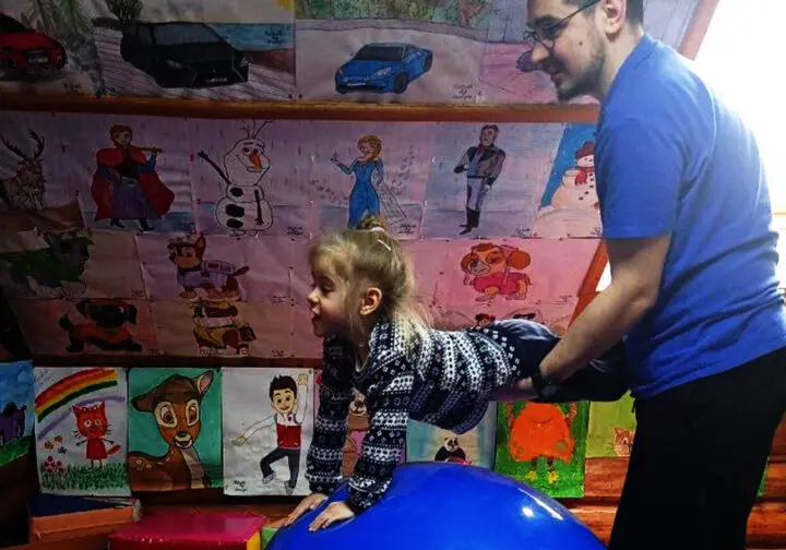 flicka lyfts upp ovanför en studsboll