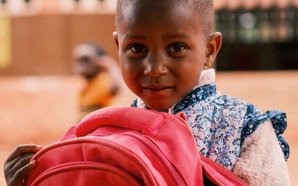 Litet barn bär på en väska