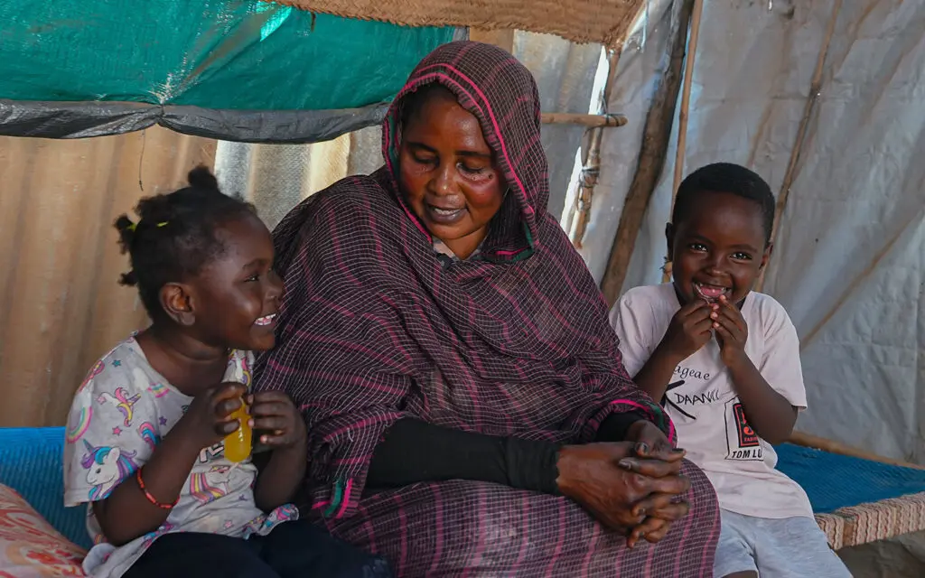 Mamma med två barn i ett tält i Sudan