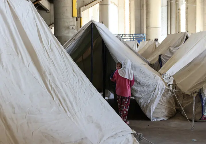 Kvinna och barn i tältläger.