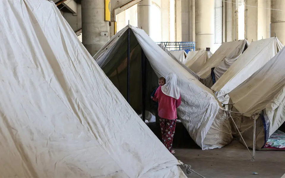 Kvinna och barn i tältläger.