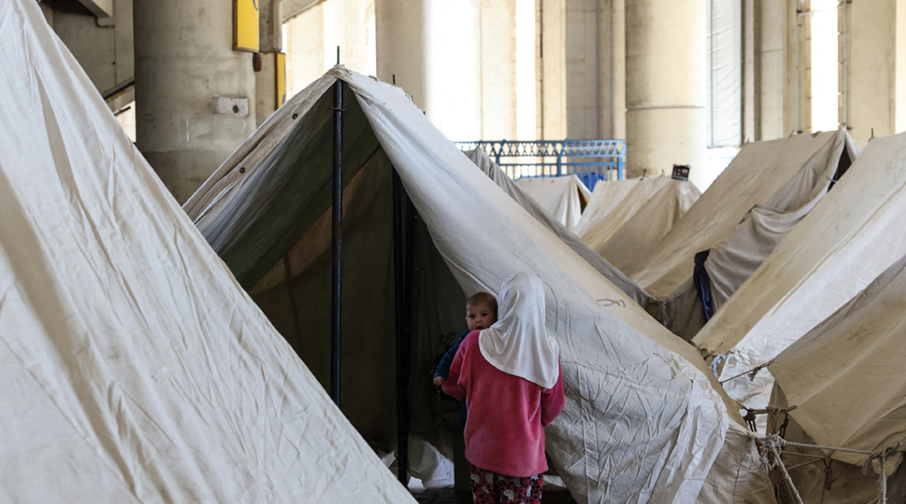 en mamma och barn i tältläger
