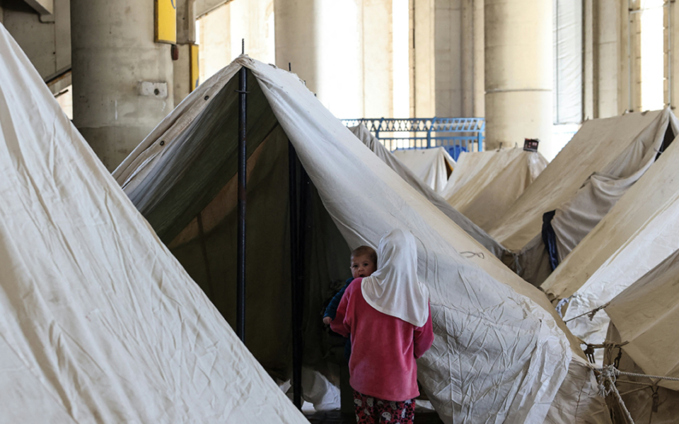en mamma och barn i tältläger