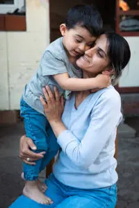 Pojke och mamma kramar om varandra hårt