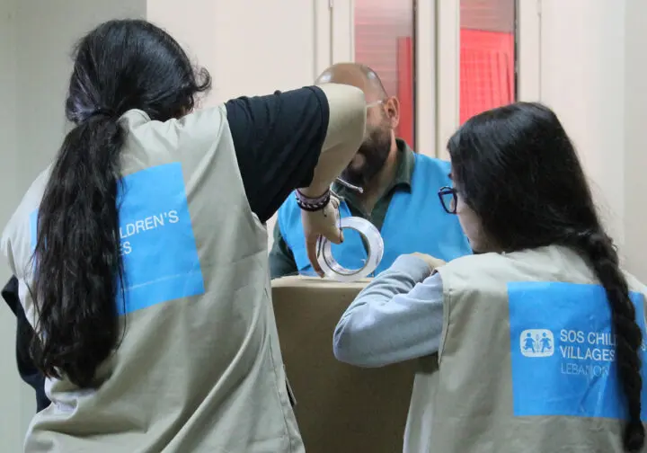 Hjälparbetare i Libanon med SOS Barnbyars västar packar kartonger