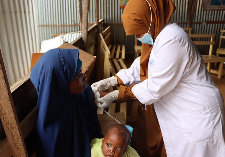 Mamma och barn hjälp av sjuksköterska på SOS Barnbyars klinik.