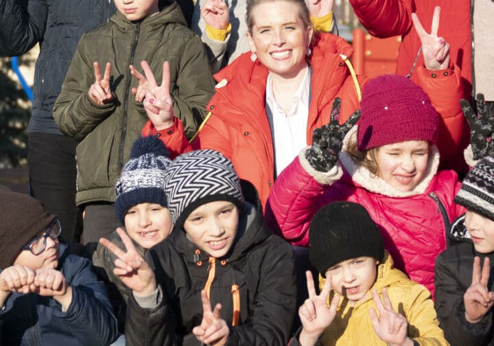ukraniska barn gör peace-tecken och tittar in i kameran.