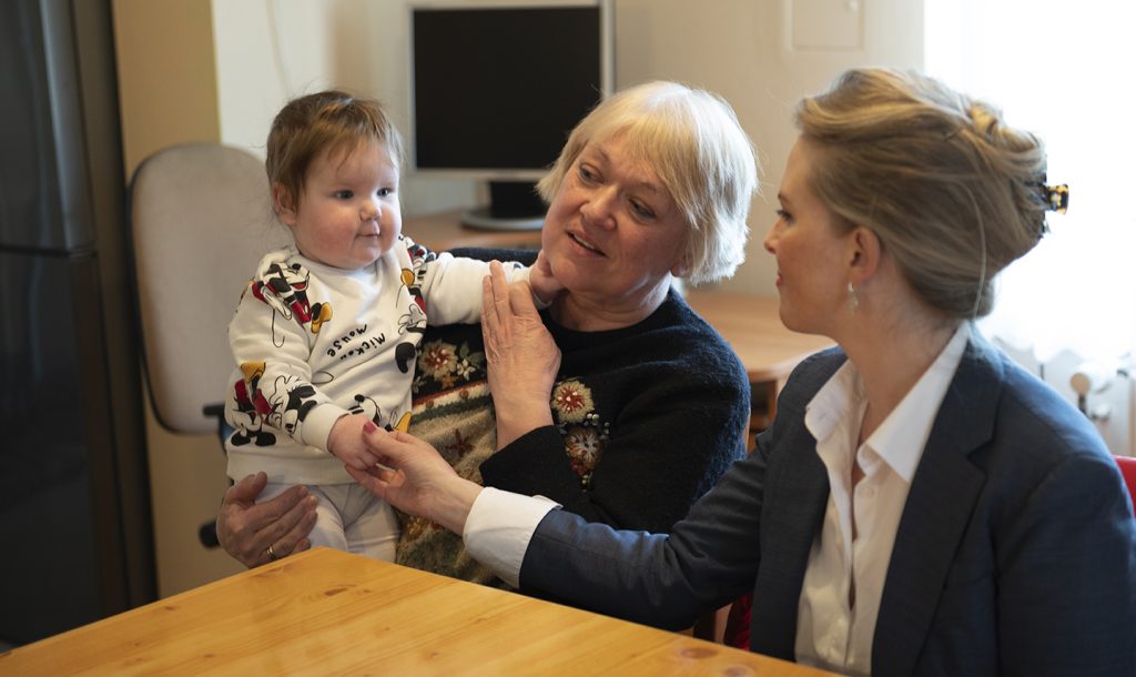 SOS Barnbyars VD Ingrid Johansen tillsammans med en fosterförälder och ett barn i SOS Barnbyars omsorg.