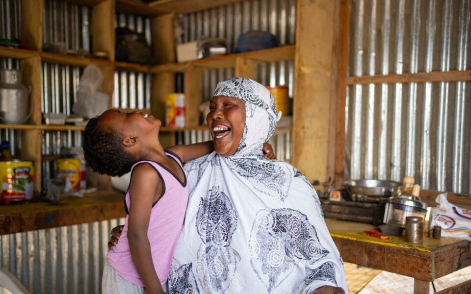 En kvinna som deltar i SOS Barnbyars familjestärkande program skrattar tillsammans med hennes barn.