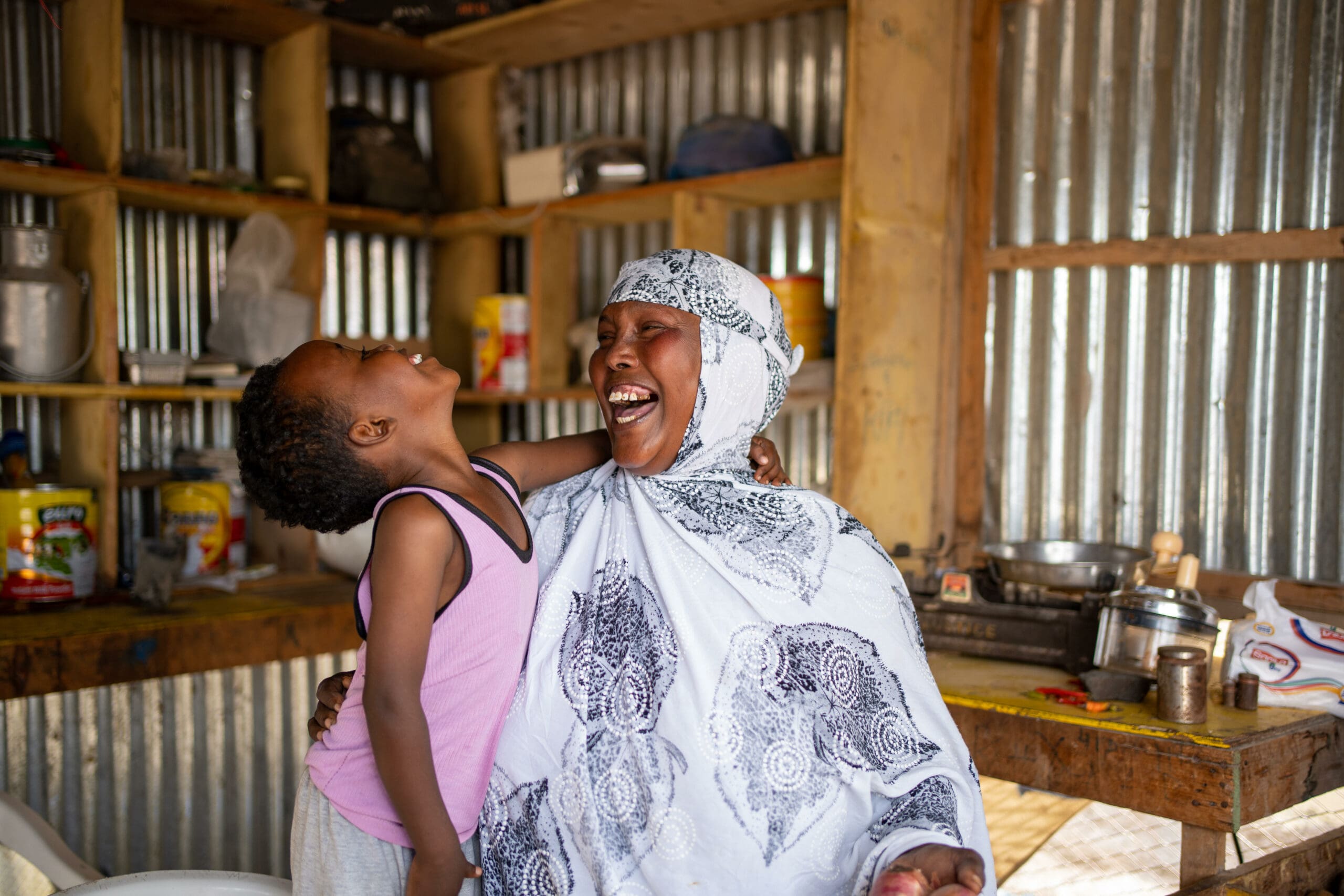 En kvinna som deltar i SOS Barnbyars familjestärkande program skrattar tillsammans med hennes barn.