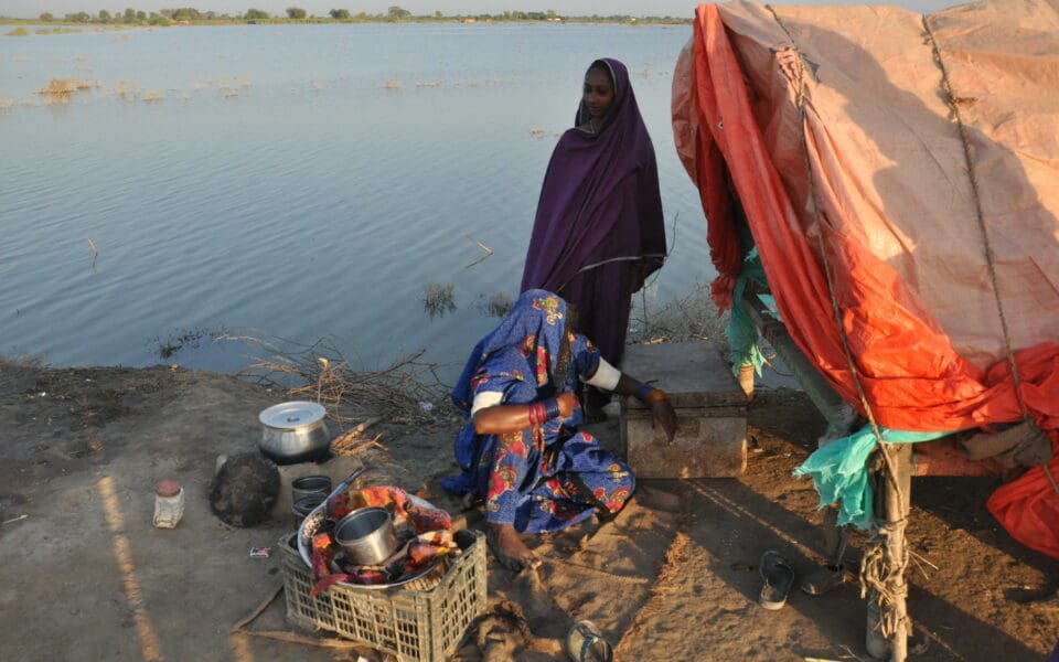 En familj som bor i ett tält vid vattnet efter översvämningar i Pakistan.