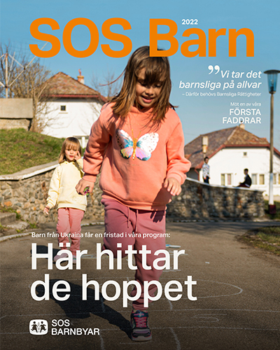 Tidningsomslag SOS Barn 2022, två flickor från Ukraina som hoppar hopphage.