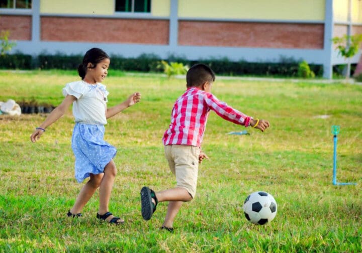 Barn som spelar fotboll.