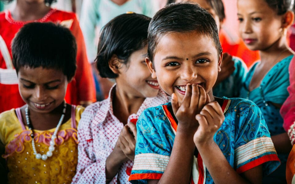 Ett barn i SOS Barnbyars program i Bangladesh som tittar in i kameran och ler.
