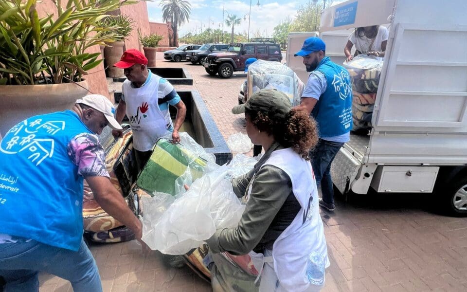 SOS Barnbyars personal som lastar skåpbil med förnödenheter.