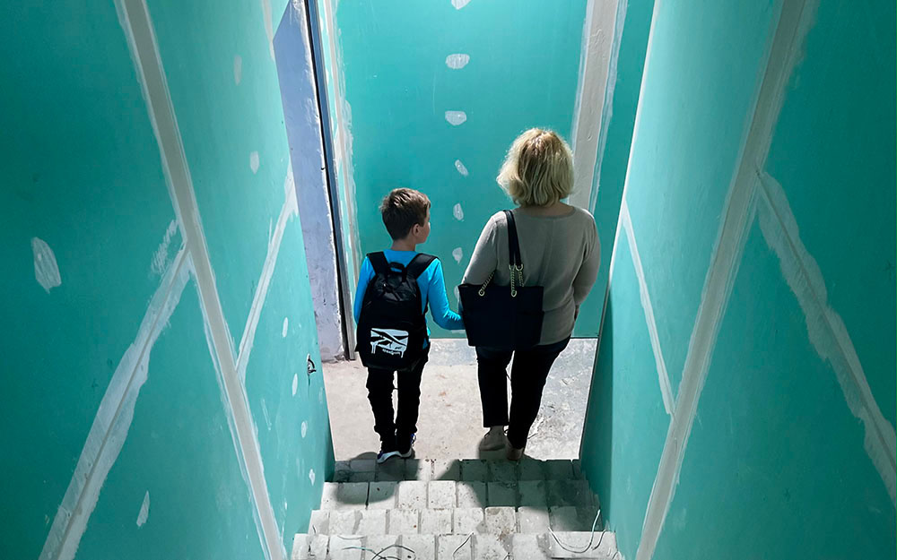 En kvinna och en pojke som går ner för en trappa.