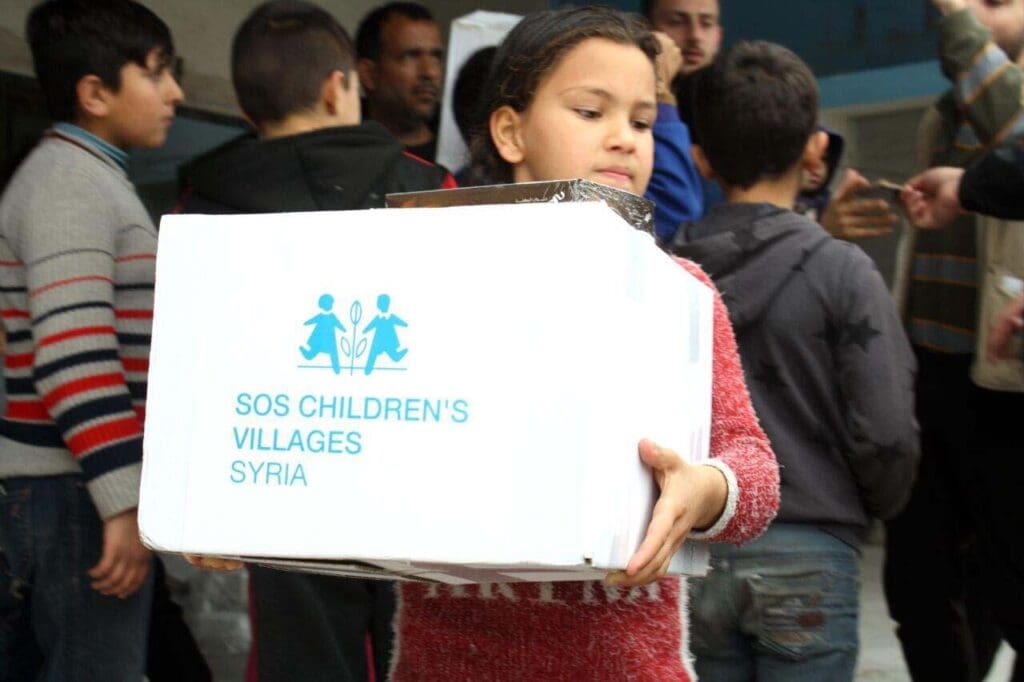 Barn med paket med katastrofstöd efter jordbävningen i SYrien 2023.