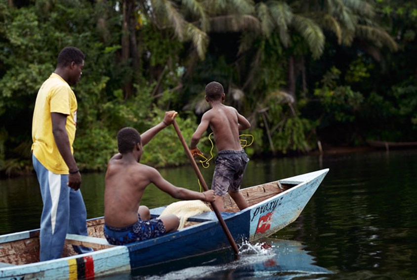 Unga pojkar i ranglig båt på stor flod