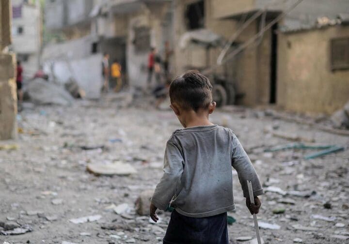 Ensam pojke bland förstörda byggnader i Gaza.