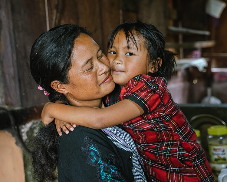 En kvinna och ett barn som kramas.