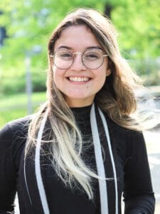 Ung tjej i svart tröja utomhus ler