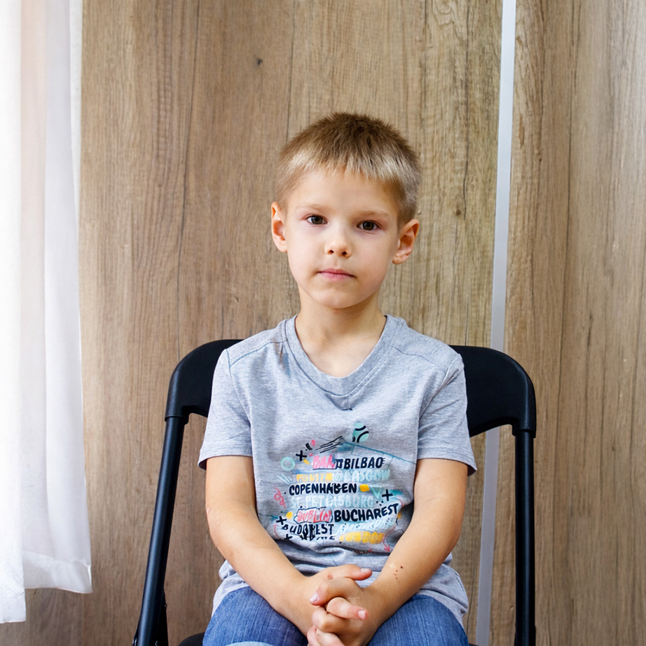 En pojke som sitter på en stol.