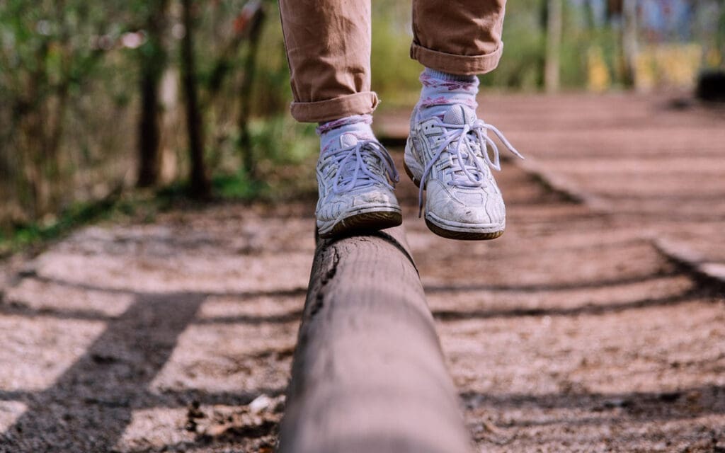 Fötter av tonåring som balanserar på en bräda