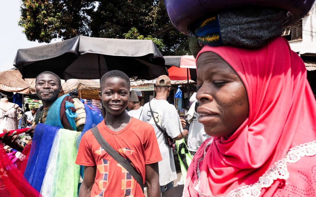 Myller på marknaden en kvinna bär tungt bagage på huvudet