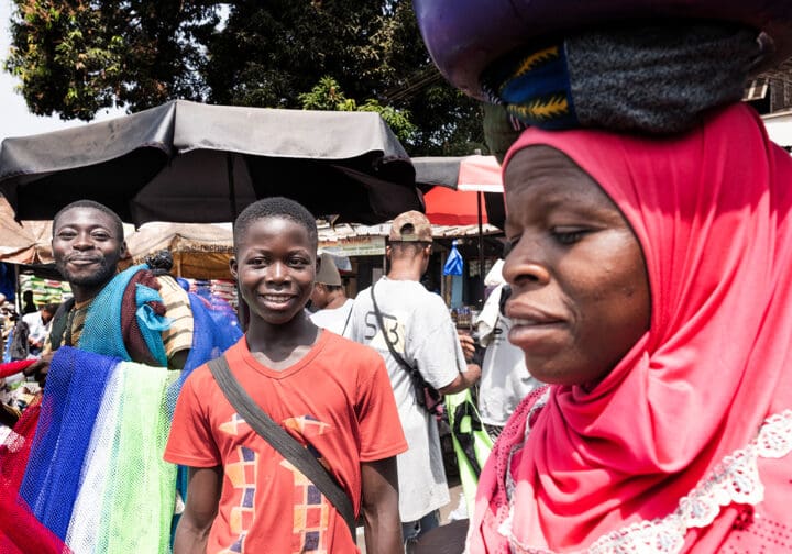 Myller på marknaden en kvinna bär tungt bagage på huvudet