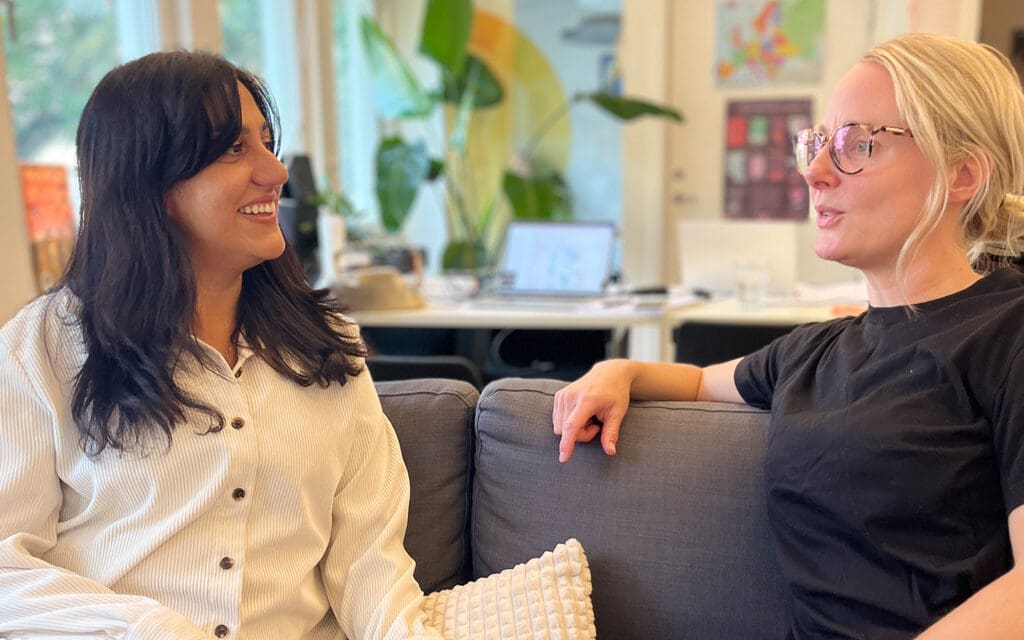 Två kvinnor pratar i en soffa