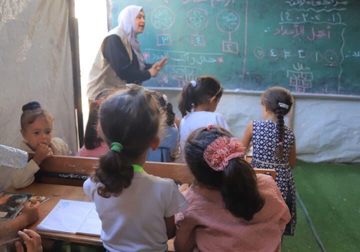 barn och lärare i provisoriskt klassrum