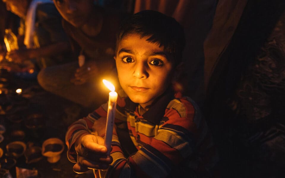 allvarlig pojke med bruna ögon håller ett ljus