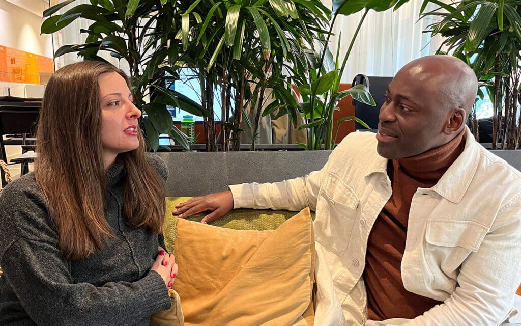 En kvinna och en man samtalar i en soffa