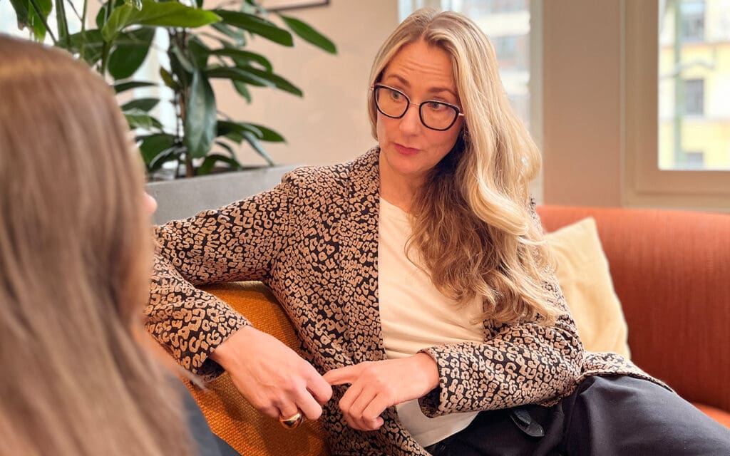 kvinna i soffa talar seriöst med annan kvinna