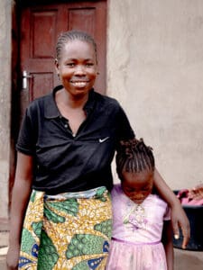 Mamma håller om sin lilla dotter i rosa klänning