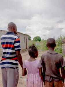 Tre syskon bakifrån håller handen