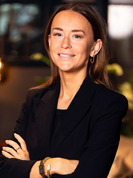 Kvinna i svart kavaj ler mot kameran