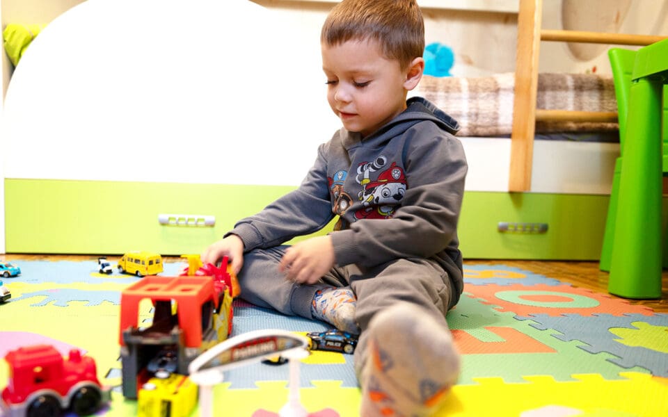 Pojke på golvet leker med lastbil