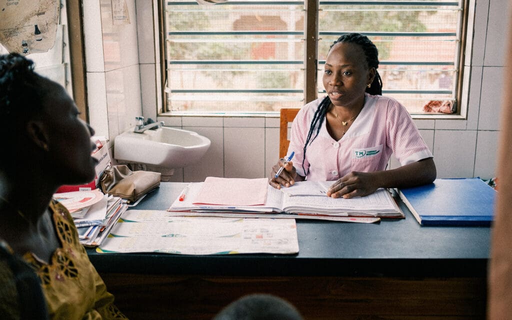 Barnmorska sitter i klinik och pratar med patient