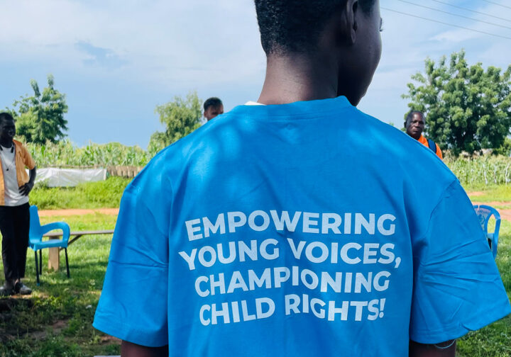 pojke i Ghana bakifrån med blå t-shirt med texten empowering young voices