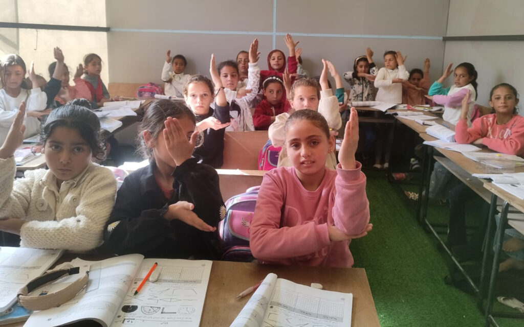 barn sitter i ett temporärt klassrum i ett tältläger i gaza