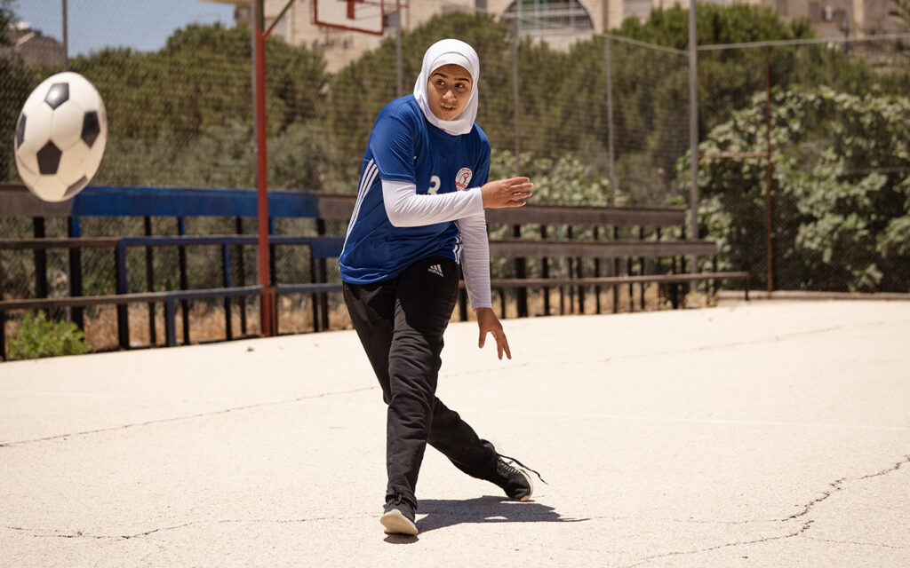 Flicka i Jordanien spelar fotboll utomhus