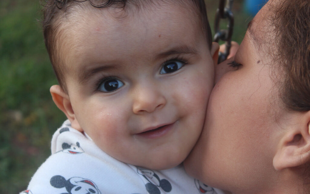 Baby med glad blick hos sin SOS-mamma